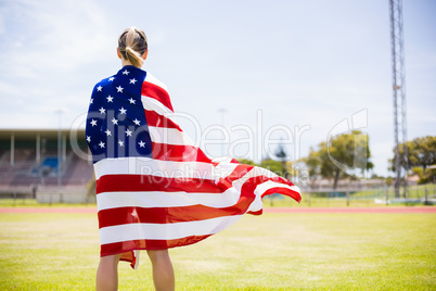 Rear view of female athlete wrapped in american flag