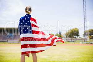 Rear view of female athlete wrapped in american flag