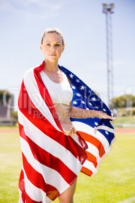 Portrait of female athlete wrapped in american flag