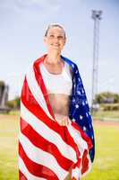 Happy female athlete wrapped in american flag