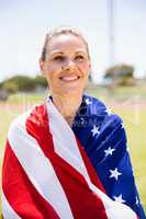 Happy female athlete wrapped in american flag