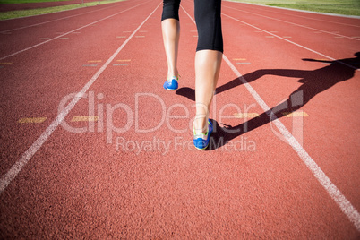 Female athlete feet running on the running track