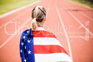 Rear view of female athlete wrapped in american flag