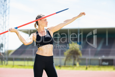 Confident female athlete about to throw a javelin