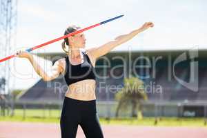 Confident female athlete about to throw a javelin