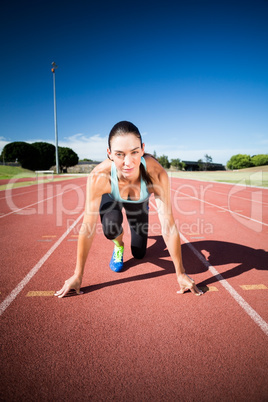 Portrait of female athlete in ready to run position