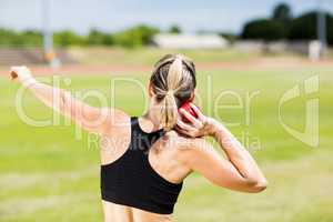 Rear view of female athlete preparing to throw shot put ball