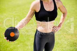 Mid section of female athlete about to throw a discus