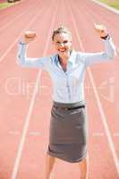 Portrait of excited businesswoman standing on the running track