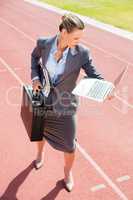 Businesswoman ready to run with a laptop and briefcase