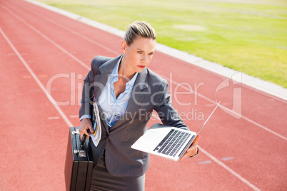 Businesswoman ready to run with a laptop and briefcase