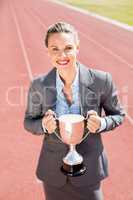 Portrait of happy businesswoman holding a trophy