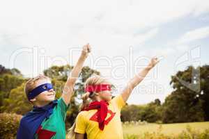 Two cute children pretending to fly in superhero costume