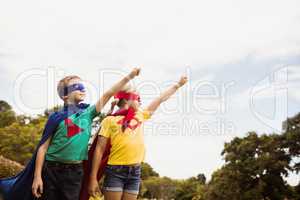 Two cute children pretending to fly in superhero costume