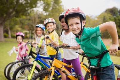 Smiling children posing in raw with bikes