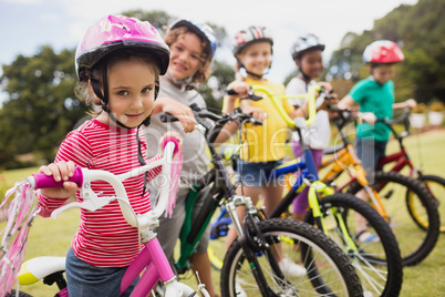 Smiling children posing in raw with bikes