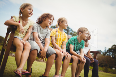 Happy children sitting on a bench