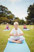 Portrait of child doing yoga with friends