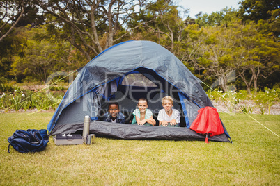 Smiling children lying in the tent