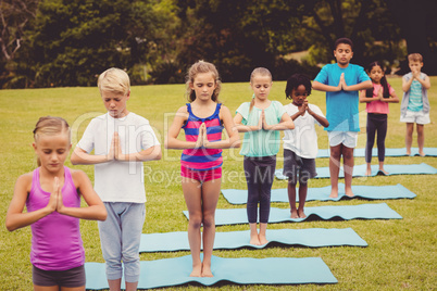 Children standing and doing yoga