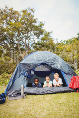 Smiling children lying in the tent