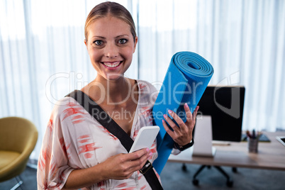 Casual business woman holding yoga mat