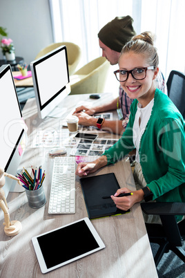 Casual colleagues using graphic tablet and computer