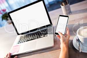 Hand holding a smartphone with computer