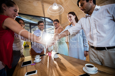 Casual colleagues putting hands together