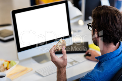 Casual businessman eating a sandwich