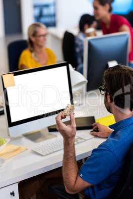 Casual businessman eating a sandwich