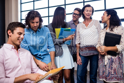 Group of coworkers holding folders and interactng