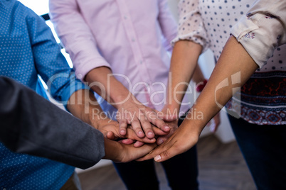 Group of coworkers putting hands together