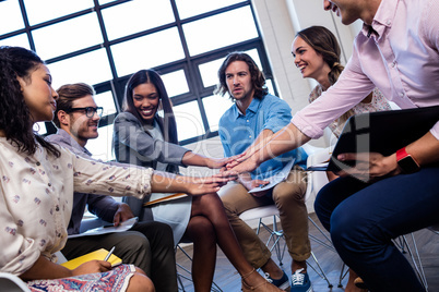 Group of coworkers putting hands together during meeting