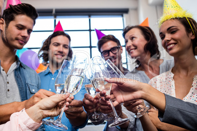 Happy coworker drinking champagne to celebrate a birthday