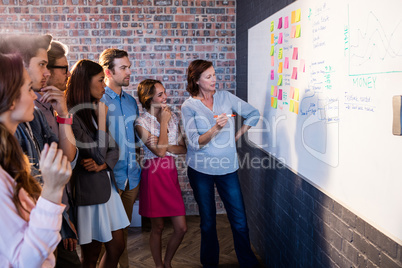 Group of coworkers analyzing a board