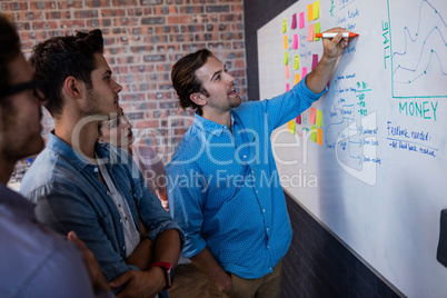 Coworkers interacting front of a board