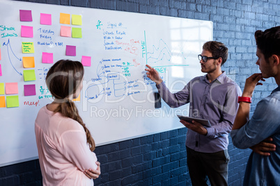 Coworkers interacting front of a board