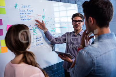 Coworkers interacting front of a board