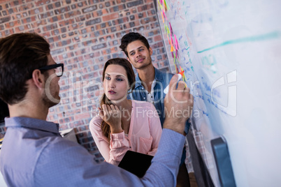 Coworkers interacting front of a board