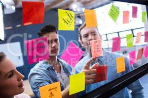 Hipsters reading a post it on a window