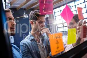 Hipsters reading a post it on a window