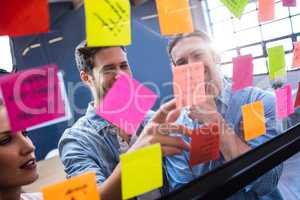 Hipsters reading a post it on a window