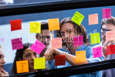 Hipsters reading a post it on a window