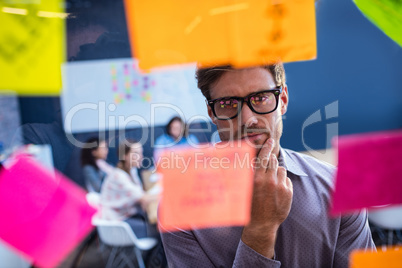 Hipster reading a post it on a window