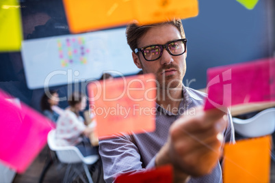 Hipster reading a post it on a window