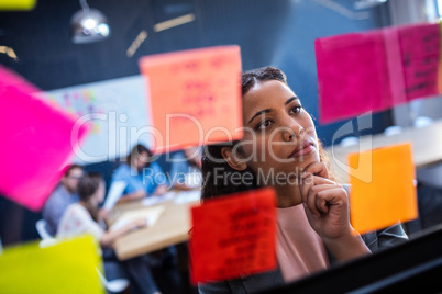 Hipster reading a post it on a window