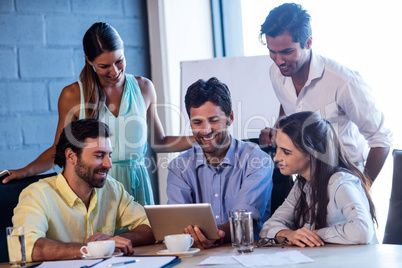 Group of smiling coworkers using a laptop