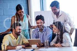 Group of smiling coworkers using a laptop