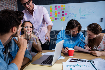 Group of coworkers interacting around a table